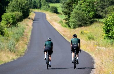 deux cyclistes en train de rouler sur une route en plein été
